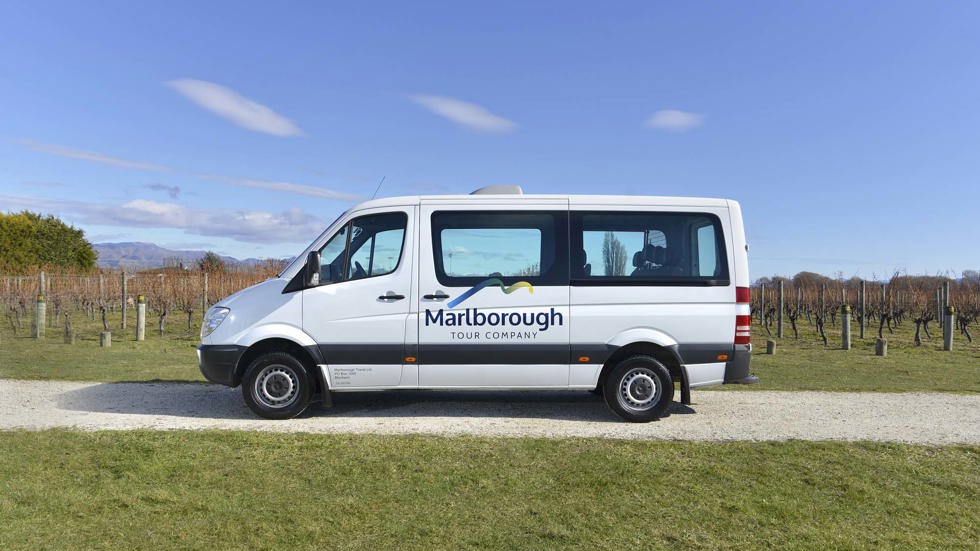 Close up of white van parked in vineyard on a Marlborough Tour Company wine tour, near Blenheim in Marlborough at the top of New Zealand's South Island.